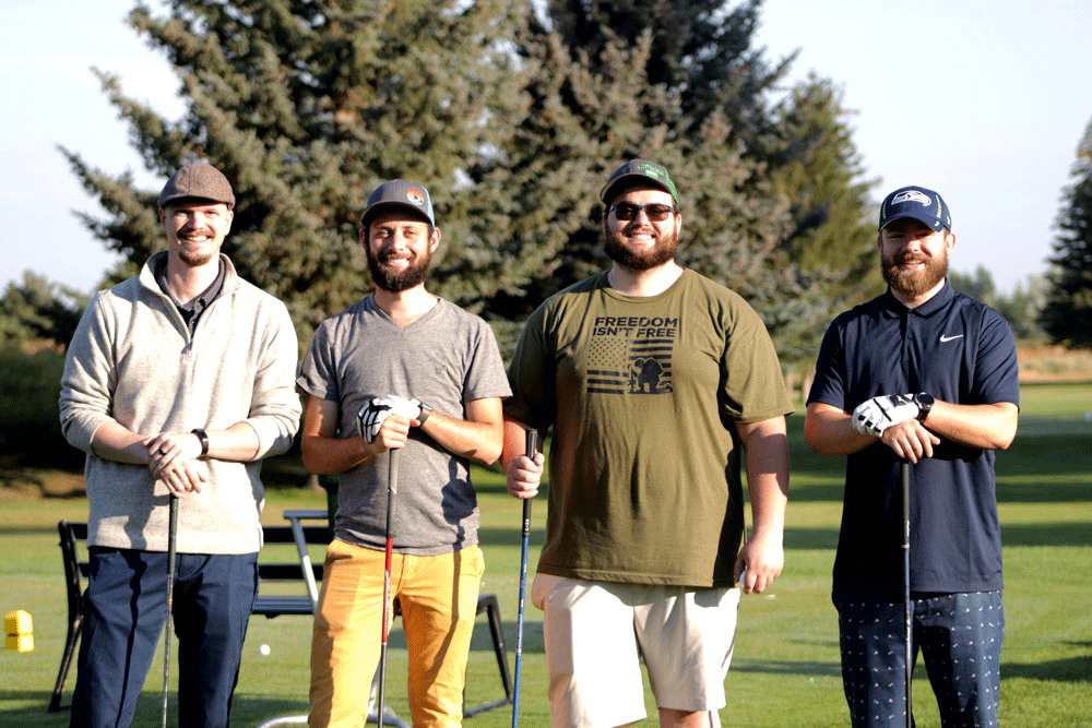 Melaleuca employees standing with their golf clubs.