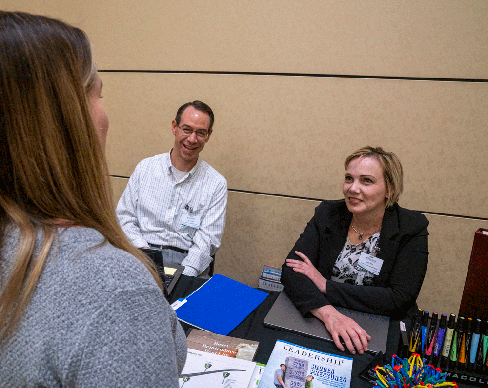 Melaleuca Team Members Dan Jewell and Lara Hays discuss the company’s Leadership in Action magazine with a candidate.