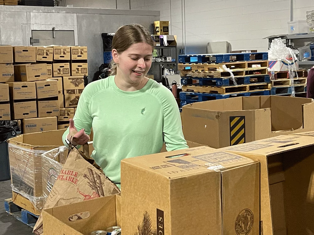 Melaleuca employee sorting food at community food basket